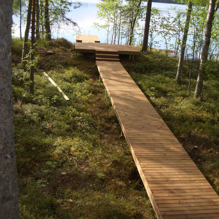 Metsäiseen maisemaan rakennetut laituri ja terassi
